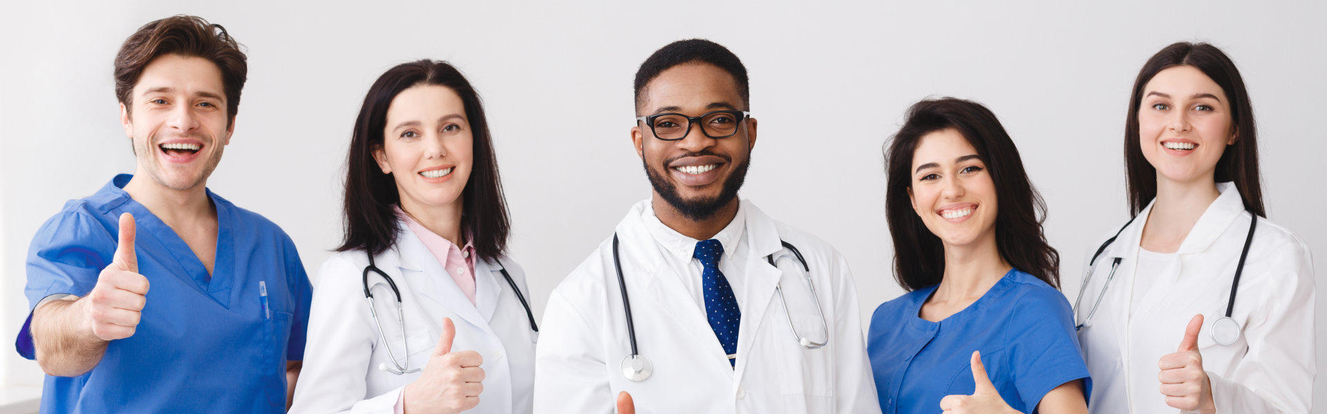 group of happy healthcare staffs showing thumbs up